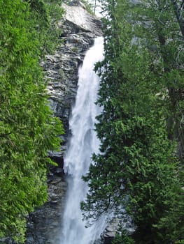 Beautiful Mountain Waterfall Surrounded by Wooded Wilderness