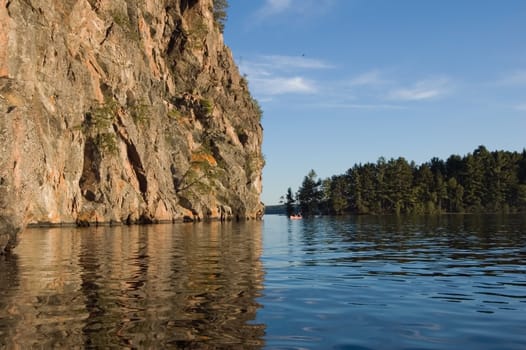 High cliff at shore of Mazinaw Lake in sunset light