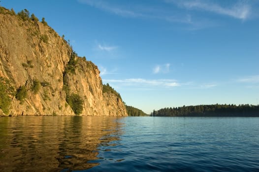 High cliff at shore of Mazinaw Lake in sunset light