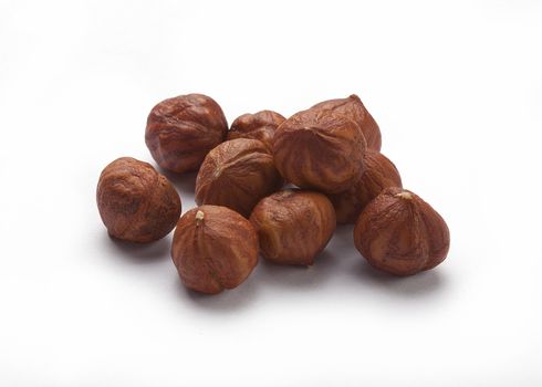 handful of brown hazelnuts on the white background