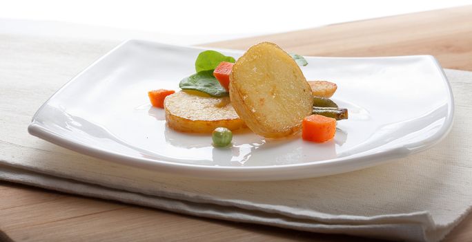 Fried potato with lettuce and vegetables on the white plate