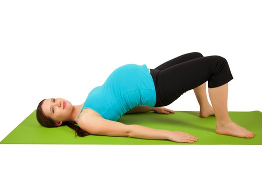 Pregnant young women stretching and exercising on the green yoga mat. 37 weeks.