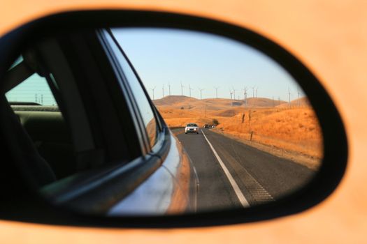 Side mirror view of a speeding car.
