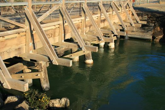 Small wood bridge built over a river.
