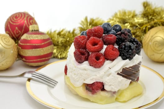 Festive dessert decorated with raspberries, blueberries and mulberries against holiday background