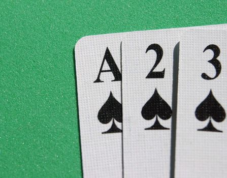 Ace,two,three of spades in a row on a green background