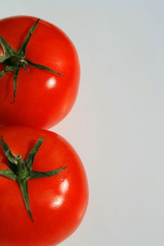 Close up of the red tomatos on a white background.
