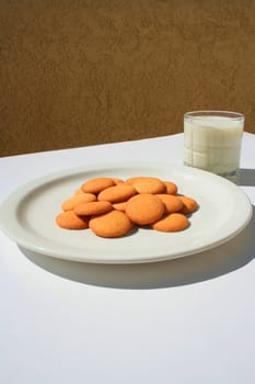 Close up of vanilla cookies and a glass of milk.
