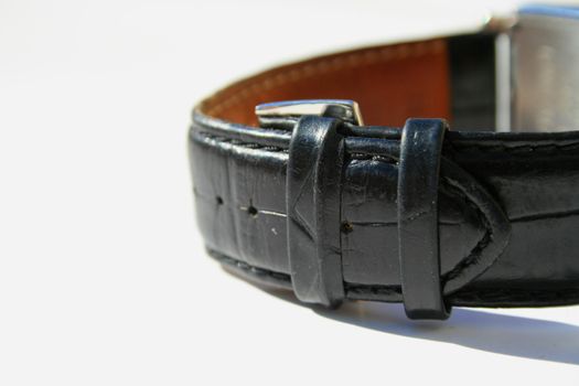 Close up of a leather watch band on a white background.
