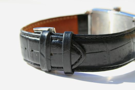 Close up of a leather watch band on a white background.

