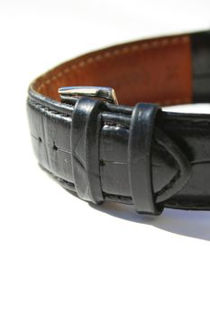 Close up of a leather watch band on a white background.
