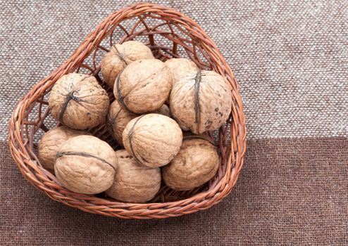 Walnuts in the old wicker basket on burlap