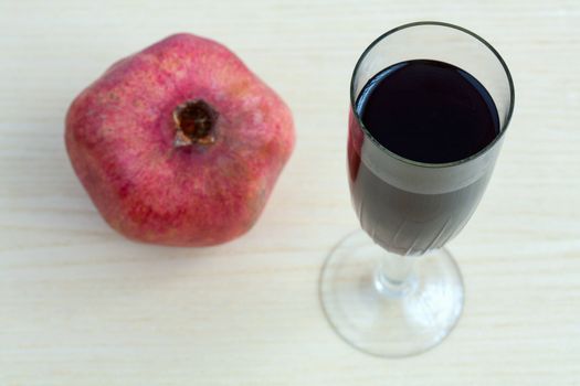 Goblet of wine and a pomegranate on the table