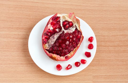 The cut pomegranate and grains on a plate