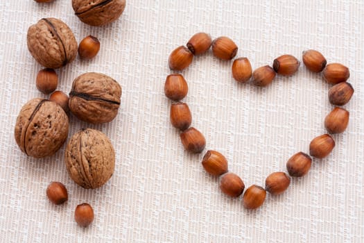 walnuts, hazelnuts on a wooden background in the form of heart