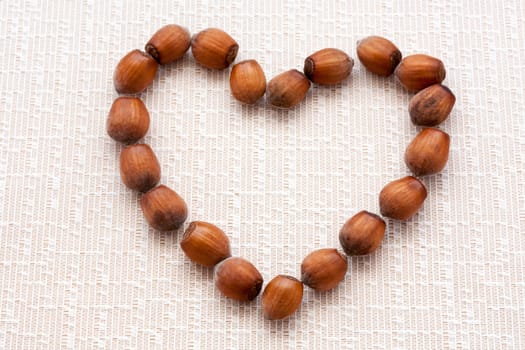walnuts, hazelnuts on a wooden background in the form of heart
