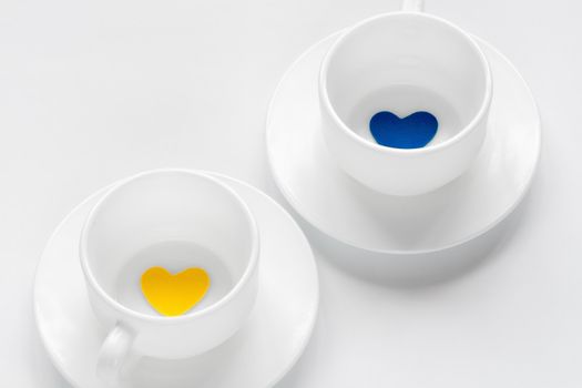 empty cup and saucer with hearts on white