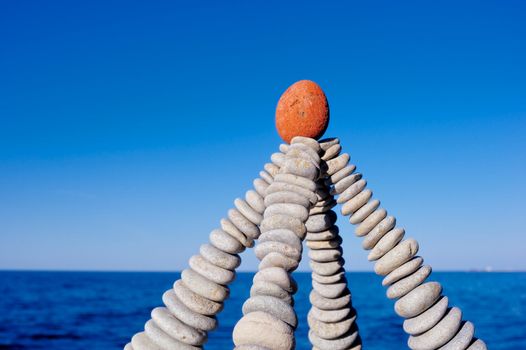 Pyramidal group of small pebbles in the balance on the seacoast