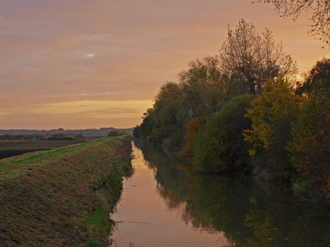 Photo taken on an autumn day at sunset from the bridge over Great Raveley Drain, at the entrance to Woodwalton fen.