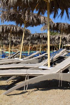 The beach near the blue sea with sun beds and umbrellas