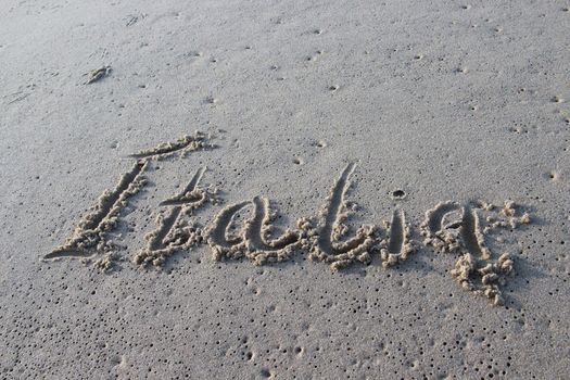 Inscription Italia on the wet sand