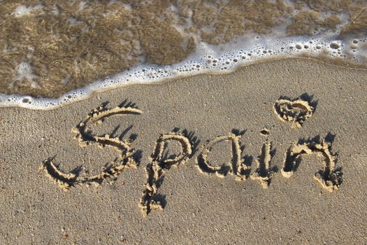 Inscription Spain on the wet sand