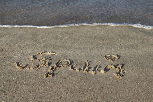 Inscription Spain on the wet sand