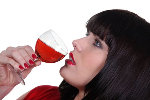 Striking shot of a woman drinking a glass of wine