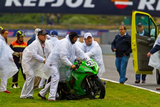 JEREZ DE LA FRONTERA, SPAIN - NOV 20: Race Stewards removing the motorcycle of Antonio Alarcos from the track in the CEV Championship race on November 20, 2011 in Jerez de la Frontera, Spain