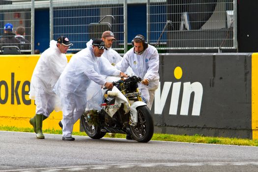 JEREZ DE LA FRONTERA, SPAIN - NOV 20: Race Stewards removing the motorcycle of Miguel Lopez from the track in the CEV Championship race on November 20, 2011 in Jerez de la Frontera, Spain