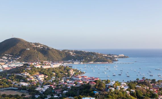 Sunset over the harbor of Charlotte Amalie in St Thomas with view over town and yachts in bay