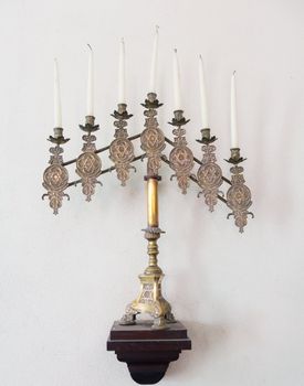 Antique ornate menorah in brass with old tallow candles