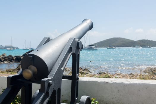 Panoramic view of Charlotte Amalie harbor with old cannon in foreground