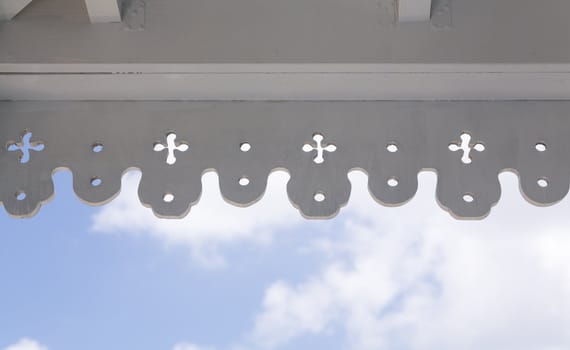 White painted antique wooden molding around veranda on old house