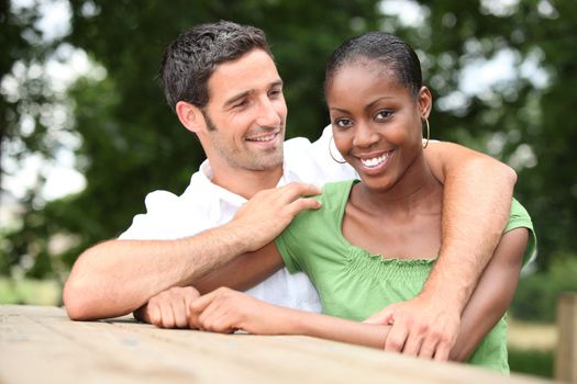 Mixed race couple cuddling in the countryside