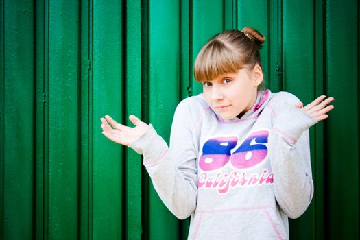 confused teenage girl on a green background