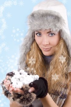 Woman in winter hat and gloves with snowflakes over blue back