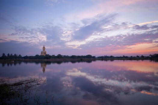 Golden Big buddha statue and lake at sunset in thailand