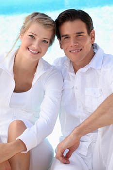Young couple wearing white with a blue sky background