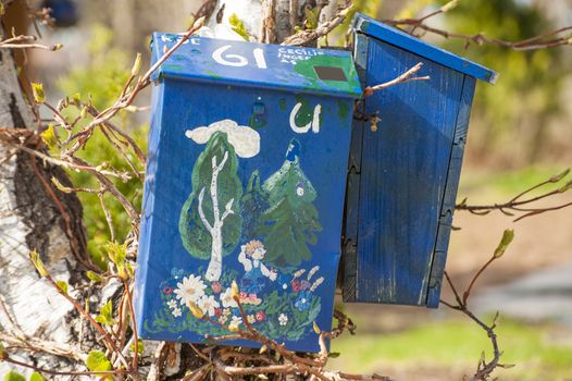 Two wooden mailboxes decorated by drawings. Taken in Norway.