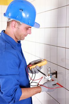 Plumber checking wiring with a voltmeter