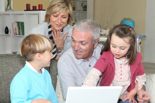 pensioners with grandchildren using computer