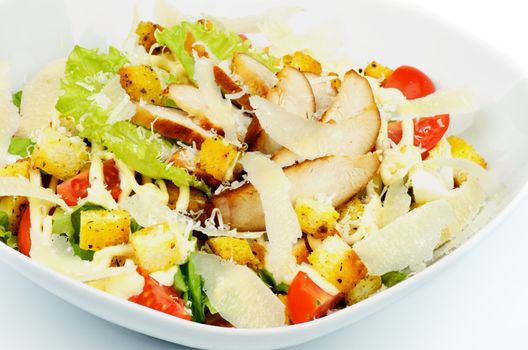 Caesar Salad with Garlic Crouton, Romaine Lettuce, Cherry Tomato, Eggs, Sauce and Grated Parmesan Cheese and Arrangement of Grilled Chicken Breast closeup in White Bowl