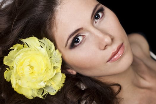 Pretty women on black background wearing yellow feathers