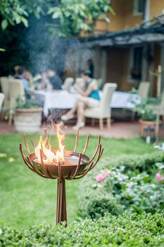 Fire Bowl in a garden, in the background some people out of focus