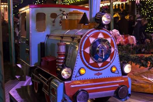 HAMBURG - DECEMBER 1, 2012: Old locomotive on a merry-go-round in a winter evening at the Christmas market in Hamburg, Germany on December 1, 2012. The famous Hamburg Christmas market is located around the town hall and is a popular tourist attraction due to its gorgeous decorated stands.
