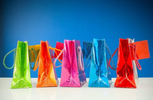 Row of colorful bags against blue background