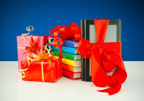 Christmas presents with electronic book reader against blue background