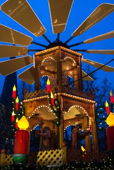 HAMBURG - DECEMBER 1, 2012: Beautifully decorated Christmas pyramid on a stand in a winter evening at the Christmas market in Hamburg, Germany on December 1, 2012. The famous Hamburg Christmas market is located around the town hall and is a popular tourist attraction due to its gorgeous decorated stands.