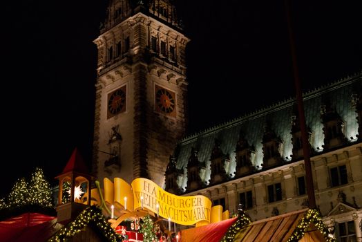 HAMBURG - DECEMBER 1, 2012: People visit traditional Christmas market in Hamburg, Germany on December 1, 2012. The famous Hamburg Christmas market is located around the town hall and is a popular tourist attraction due to its gorgeous decorated stands.